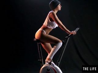 Mignonne en sueur ado sautage un exercise bike siège.